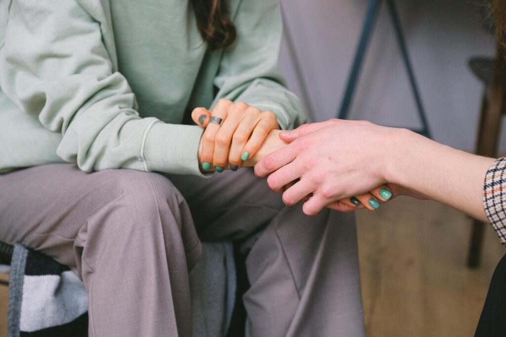 mental Close-up of two people holding hands during a comforting therapy session.